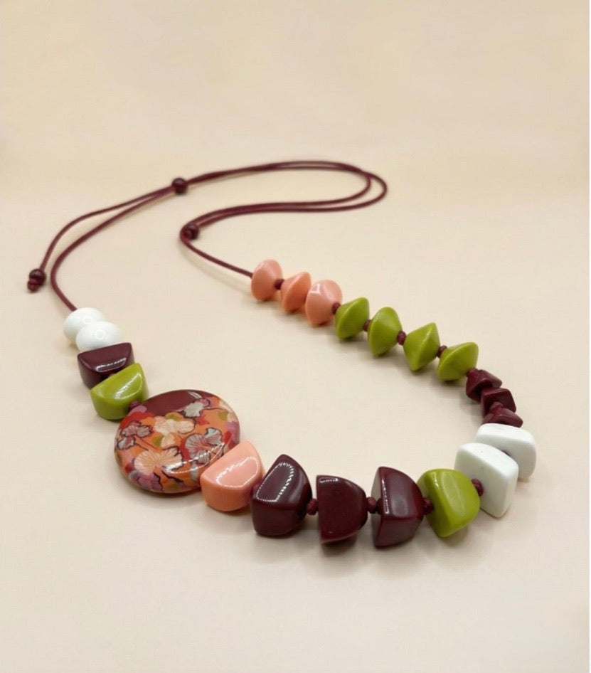 Collar floral sobre fondo rojo – Le Munir